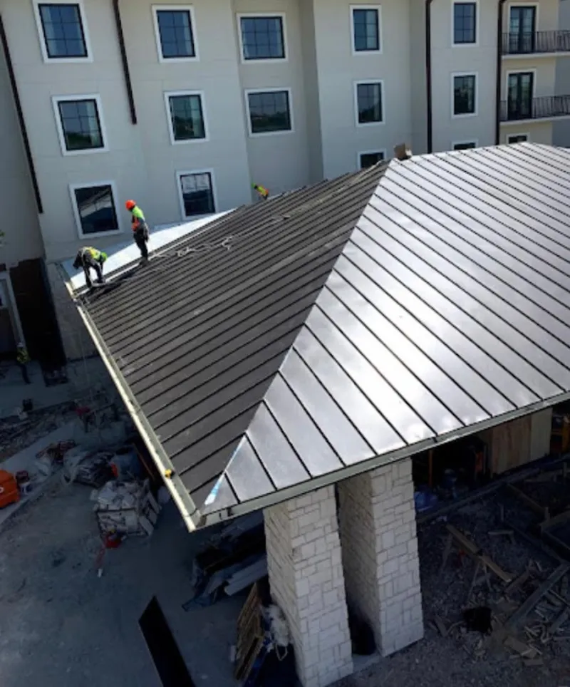 Crew installing standing seam metal roof panels on a commercial project in Dublin